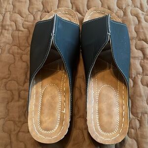 Black and tan slip on sandals. All man made material. Worn once.